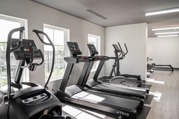 A gym with treadmills and elliptical machines.